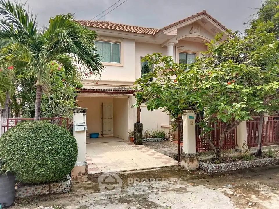 Charming two-story house with lush garden and spacious driveway in a serene neighborhood.
