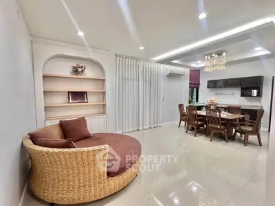 Spacious open-plan living and dining area with modern decor and elegant lighting.
