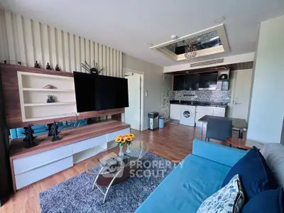 Modern living room with open kitchen, featuring stylish decor and a washing machine.