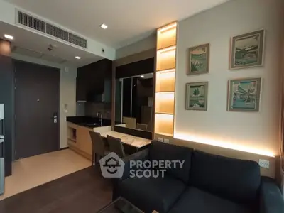 Modern living room with open kitchen, stylish decor, and cozy seating area in a contemporary apartment.