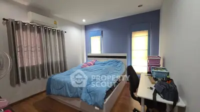 Cozy bedroom with modern decor, featuring a comfortable bed, desk, and ample natural light from two windows.