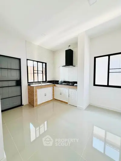 Modern kitchen with sleek design, featuring white cabinetry and black countertops, perfect for culinary enthusiasts.
