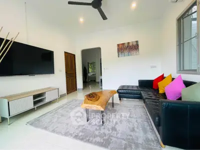 Modern living room with stylish decor and large TV, featuring a unique wooden coffee table.