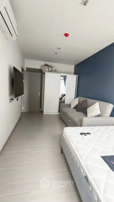 Modern bedroom with sleek design, featuring a comfortable bed, stylish sofa, and wall-mounted TV for ultimate relaxation.