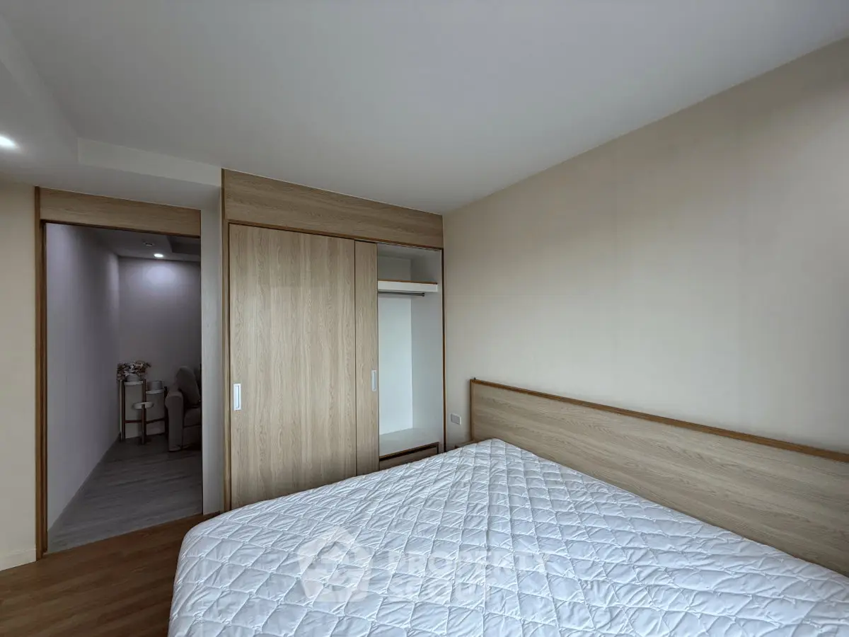 Spacious bedroom with modern wooden wardrobe and cozy bed in a minimalist design.