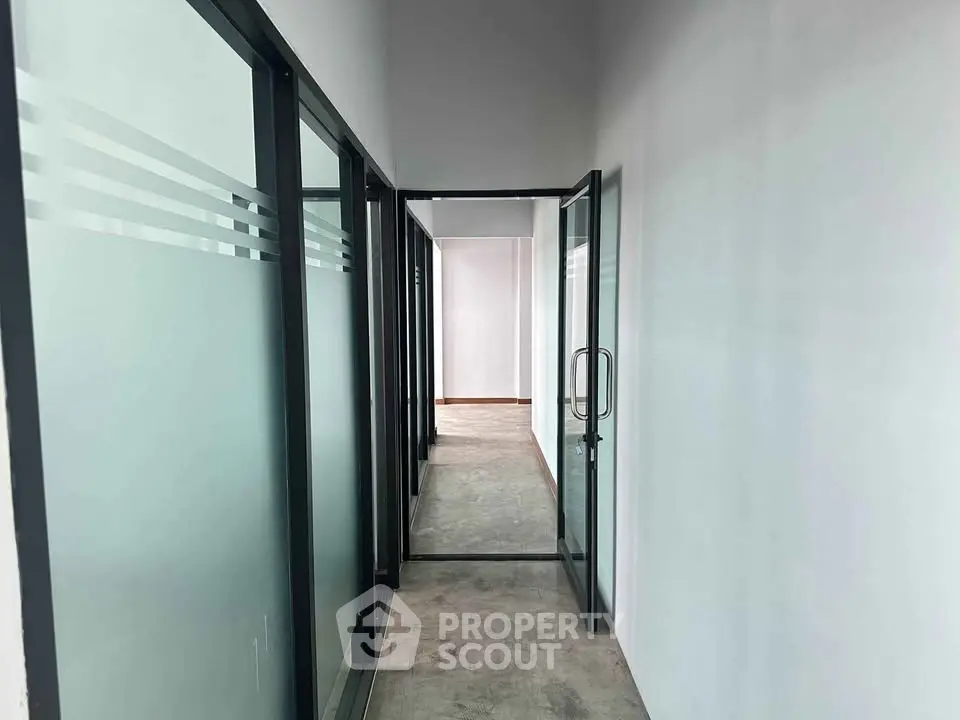 Modern corridor with glass doors and minimalist design in commercial building