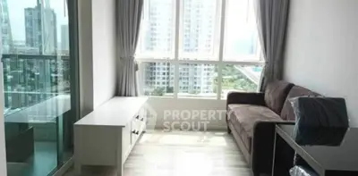 Modern living room with large windows and city view, featuring a cozy sofa and sleek furniture.