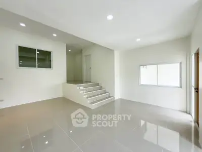Spacious modern living room with sleek tile flooring and ample natural light.