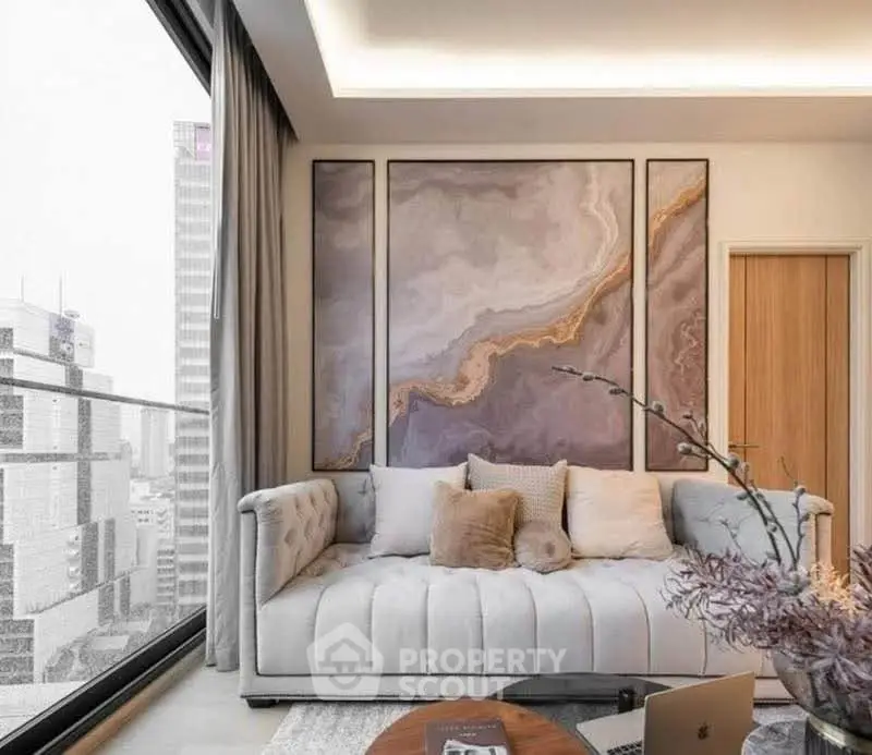 Luxurious living room with modern art and city view, featuring elegant sofa and floor-to-ceiling windows.