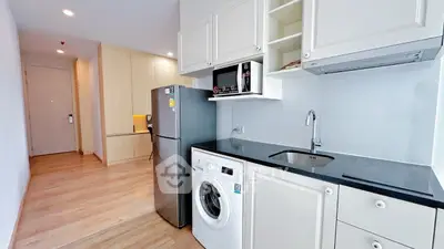 Modern kitchen with sleek appliances and wood flooring in a stylish apartment