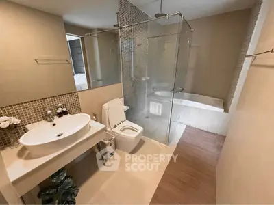 Modern bathroom with glass shower and bathtub in luxury apartment