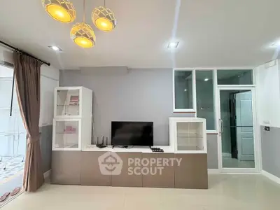 Modern living room with sleek TV unit and stylish lighting, showcasing contemporary interior design.