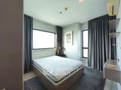 Modern bedroom with large windows and elegant curtains in a stylish apartment.