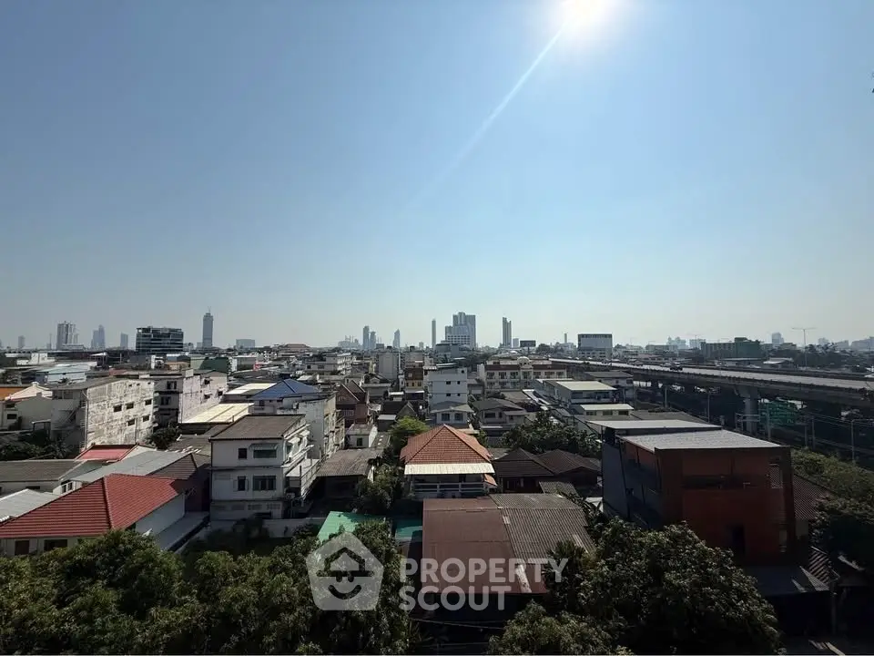 Stunning cityscape view showcasing urban skyline and residential rooftops under a clear blue sky.