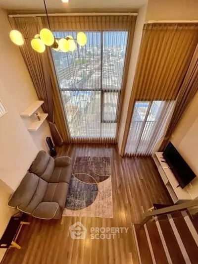 Luxurious high-ceiling living room with modern decor and stunning city view.