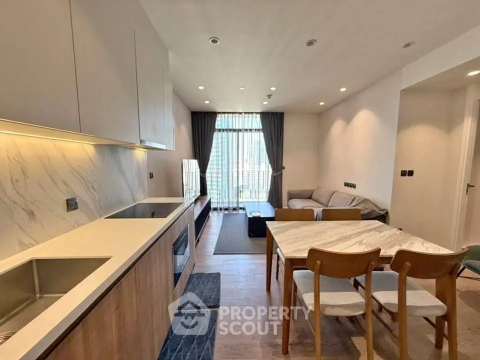 Modern open-plan living room and kitchen with stylish decor and natural light.