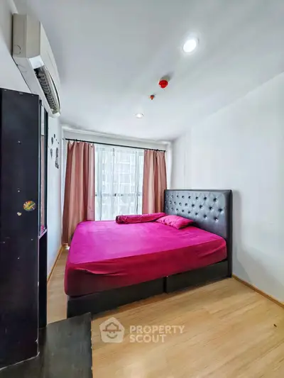 Modern bedroom with vibrant pink bedding and natural light