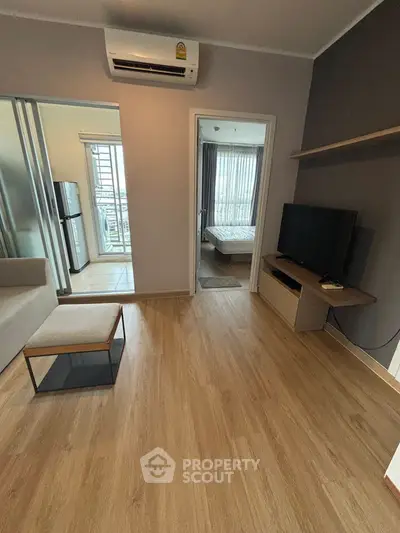 Modern living room with wooden flooring and sleek furniture in a stylish apartment.