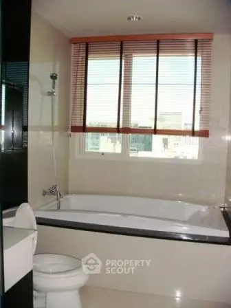 Modern bathroom with bathtub and large window offering city views