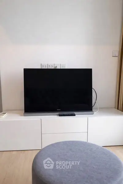 Modern living room with sleek TV setup and minimalist furniture design.