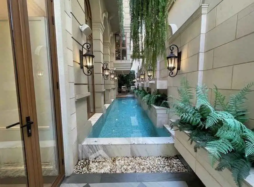 Luxurious private pool area with elegant lighting and lush greenery in a high-end property.