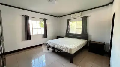 Spacious bedroom with natural light and modern furnishings