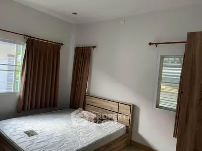 Cozy bedroom with natural light and wooden furniture, perfect for relaxation.