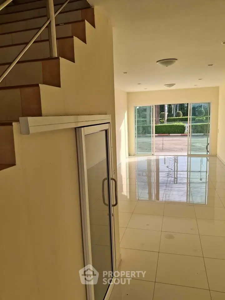 Spacious modern living room with large windows and glossy tiled floors