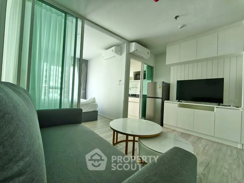 Modern living room with sleek furniture and open kitchen in a stylish apartment.