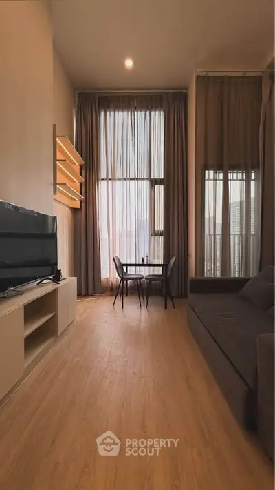 Modern living room with high ceilings, large windows, and stylish furniture.