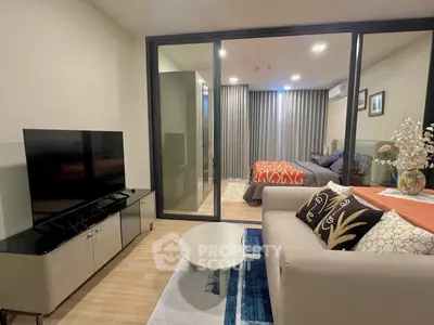 Modern living room with sleek furniture and view into cozy bedroom