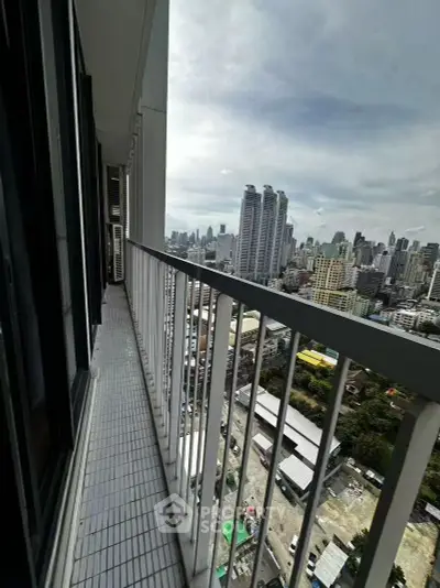 Stunning cityscape view from high-rise balcony with sleek railing design.