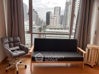 Modern living room with city view, featuring a sleek sofa and cozy chair, perfect for urban living.