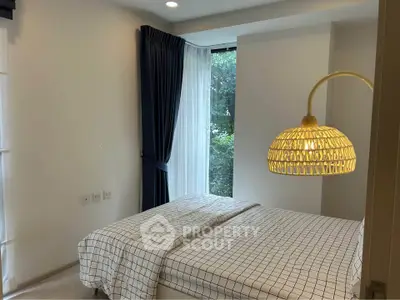 Cozy bedroom with large window and stylish lighting in modern apartment