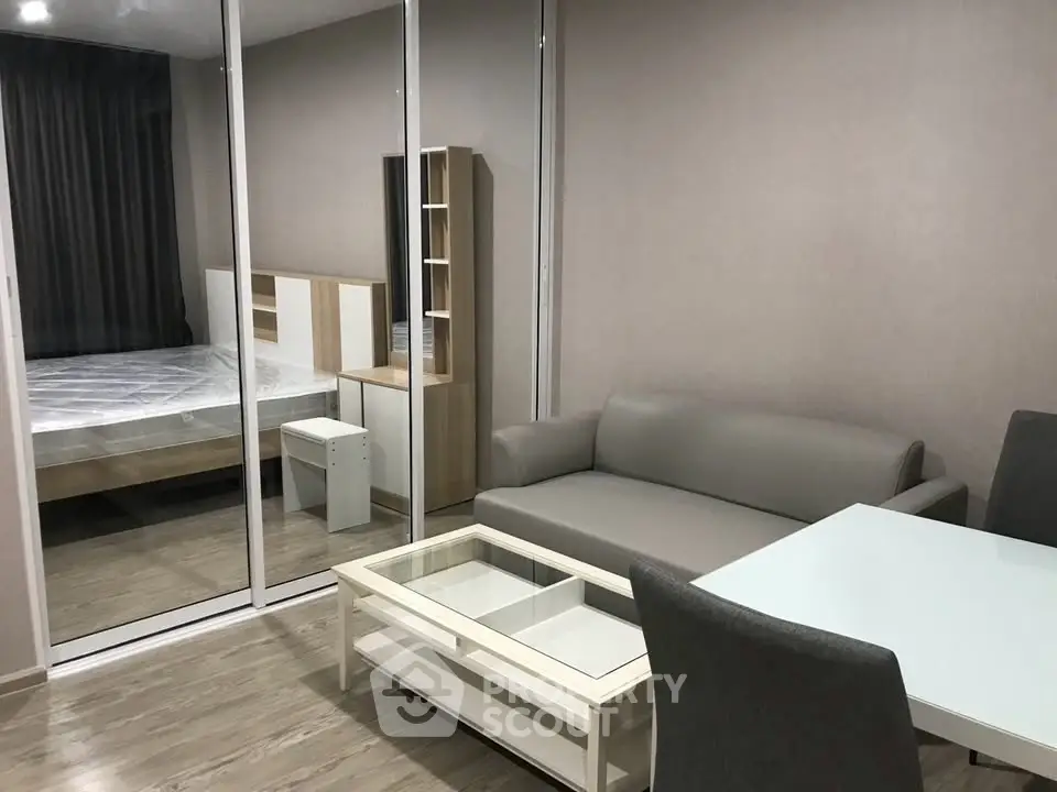 Modern studio apartment with glass partition, cozy living area, and stylish furnishings.