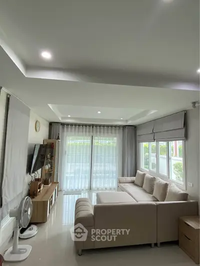 Spacious living room with modern decor and large windows for natural light