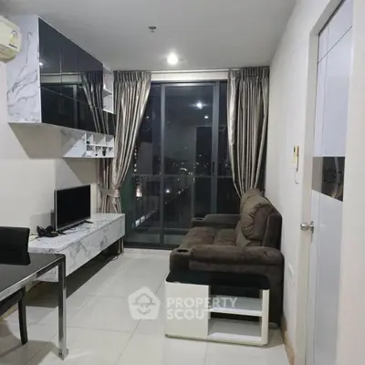 Modern living room with city view, featuring sleek furniture and floor-to-ceiling windows.
