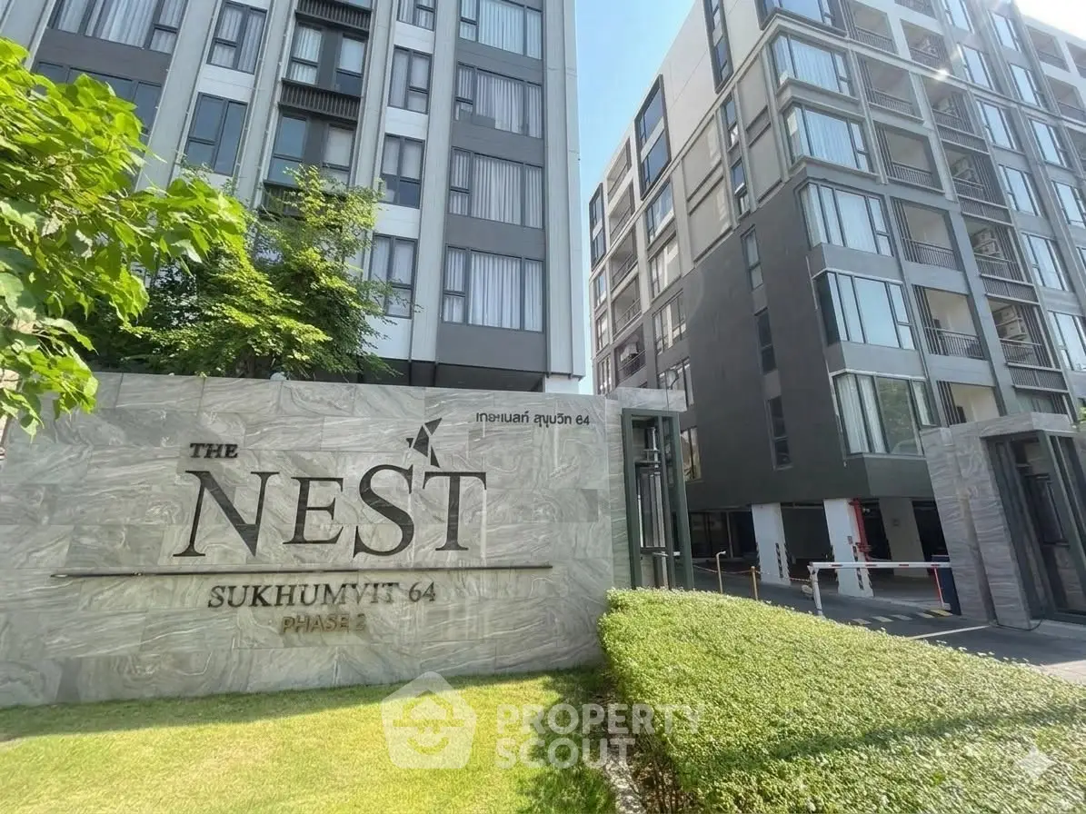 Modern condominium exterior with lush greenery at The Nest Sukhumvit 64, showcasing urban living.