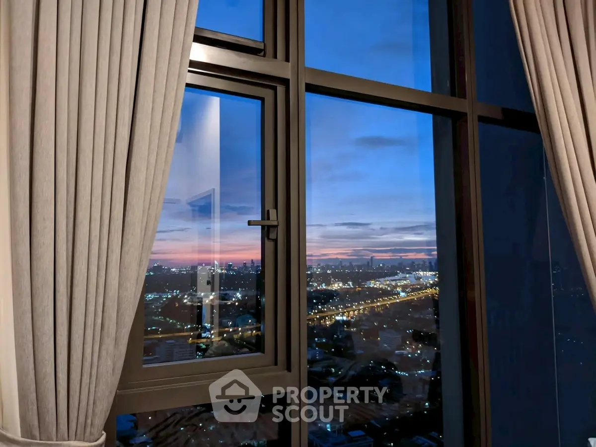 Stunning cityscape view from a high-rise apartment window at sunset.