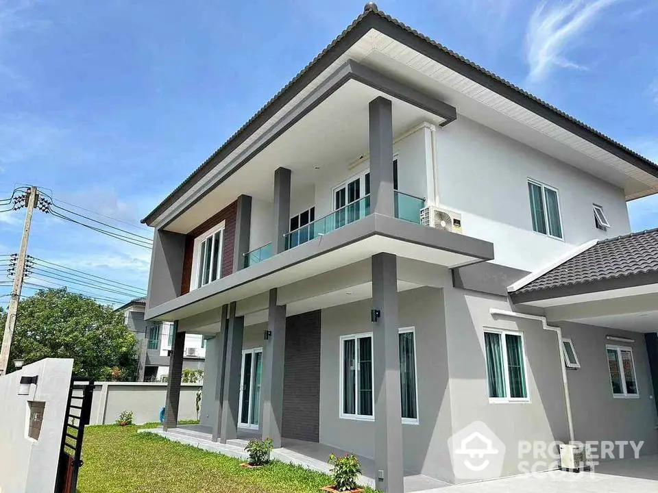 Modern two-story house with sleek design and spacious balcony in a serene neighborhood.