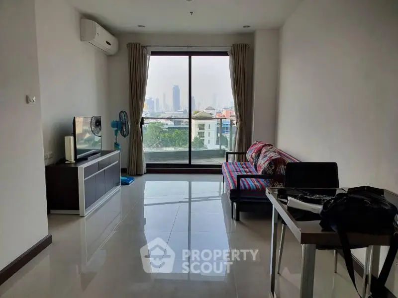 Modern living room with city view, featuring sleek furniture and large windows for natural light.