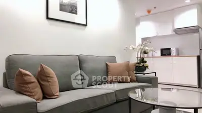 Modern living room with cozy sofa and stylish kitchen in open layout apartment.