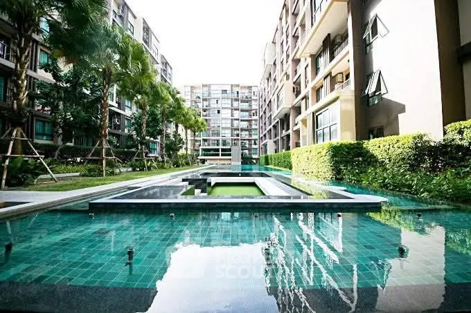 Luxurious apartment complex with modern pool and lush greenery