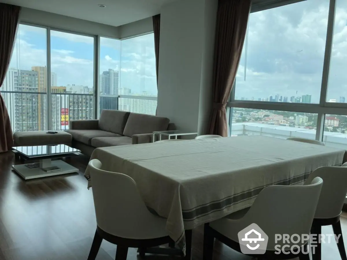 Spacious corner unit living room with panoramic city views and elegant dining area.