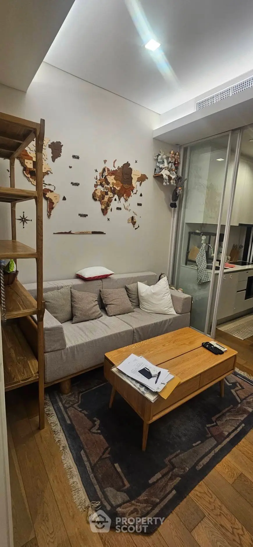Cozy living room with world map decor and modern kitchen view