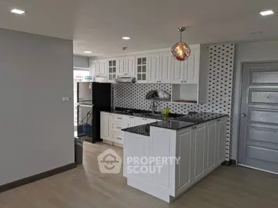 Modern kitchen with white cabinetry and stylish backsplash in a spacious open layout.