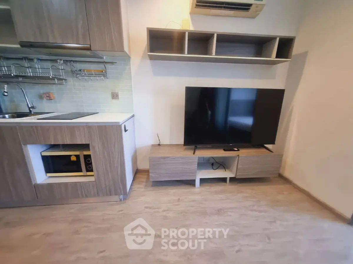Modern studio apartment with sleek kitchen and entertainment area