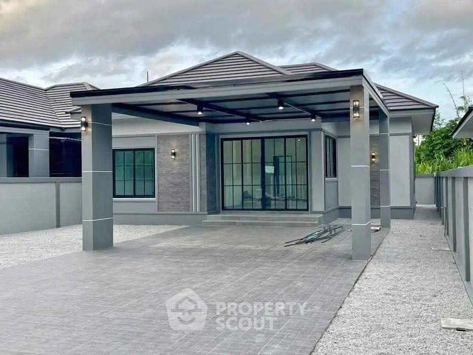 Modern single-story home with spacious driveway and sleek design.