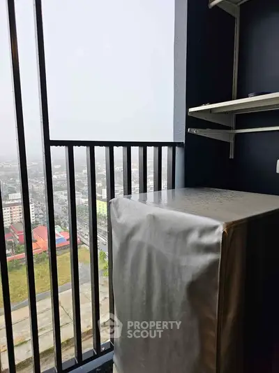 High-rise balcony with city view and covered appliance, ideal for urban living.