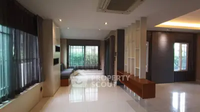 Spacious modern living room with large windows and sleek design elements.